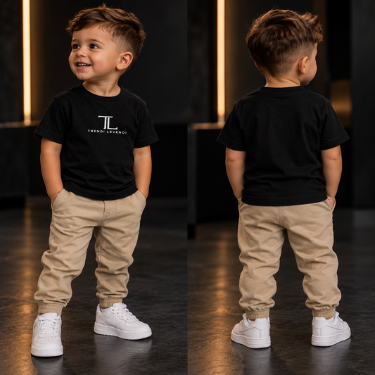 Toddler wearing black Trendi Levendi tee, dark studio lifestyle image, front and plain back